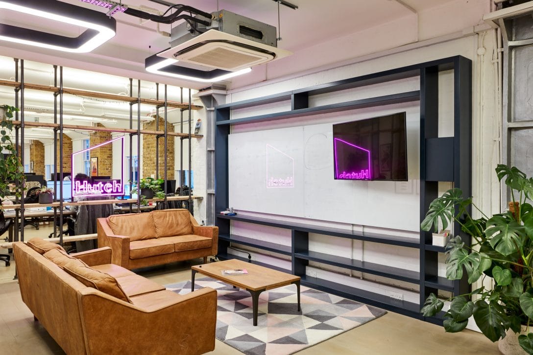 An office breakout space with comfortable sofas and a TV for staff use.
