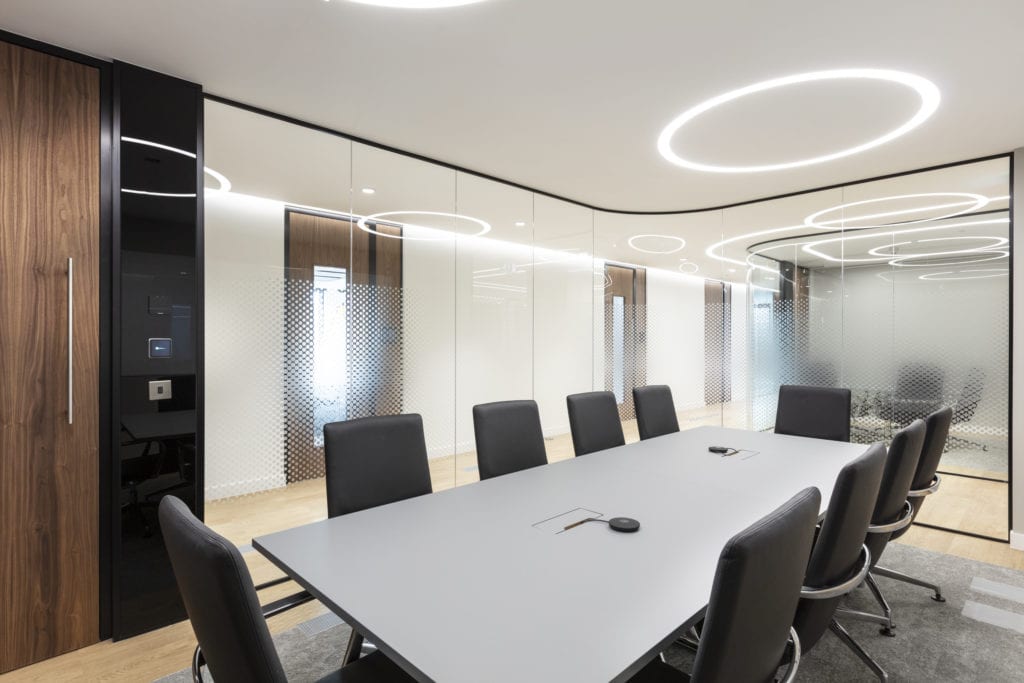 Salle de réunion du lieu de travail avec éclairage circulaire sur rail au plafond.