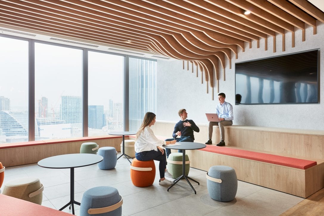 Employees are sat on bleacher seating within a collaborative office design.