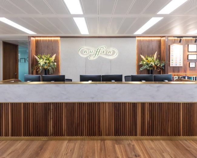 Workplace reception desk with brand graphics on the wall behind