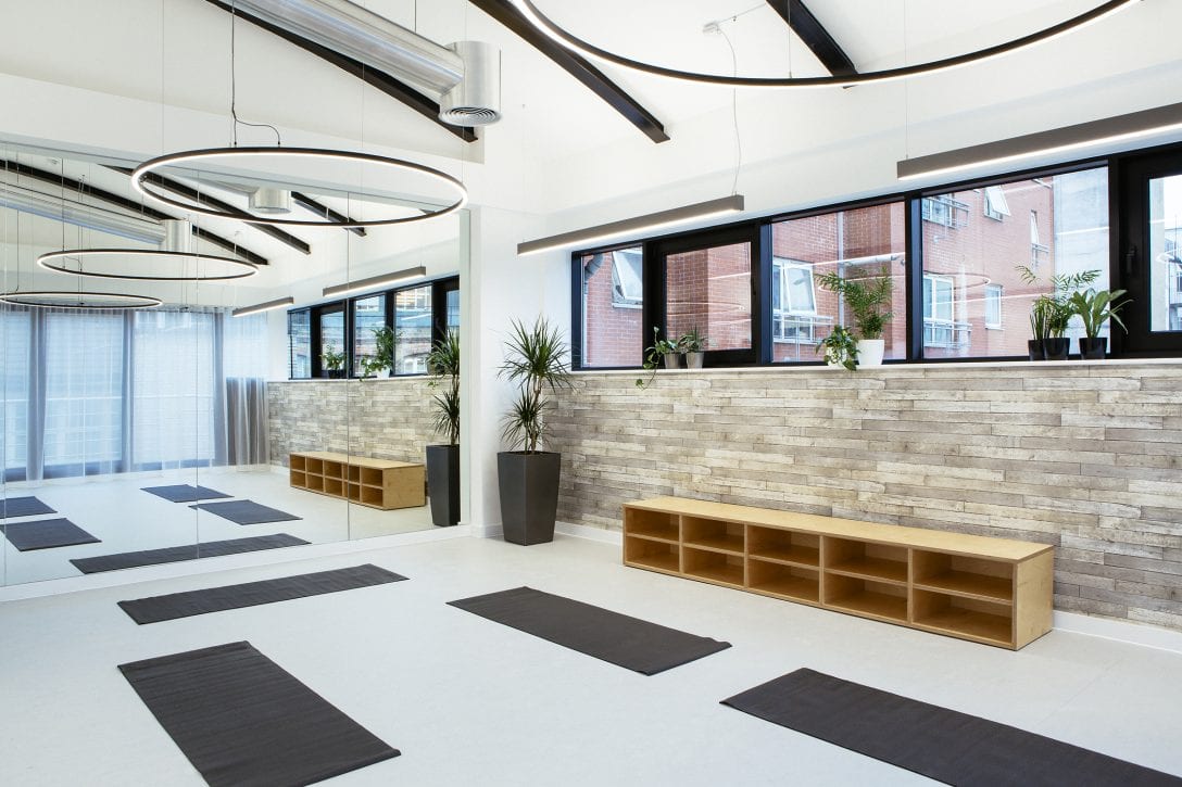 Inside the yoga room at the Arthritis Research UK offices designed and built by AIS. The space is filled with natural light and yoga mats lie on the floor. 