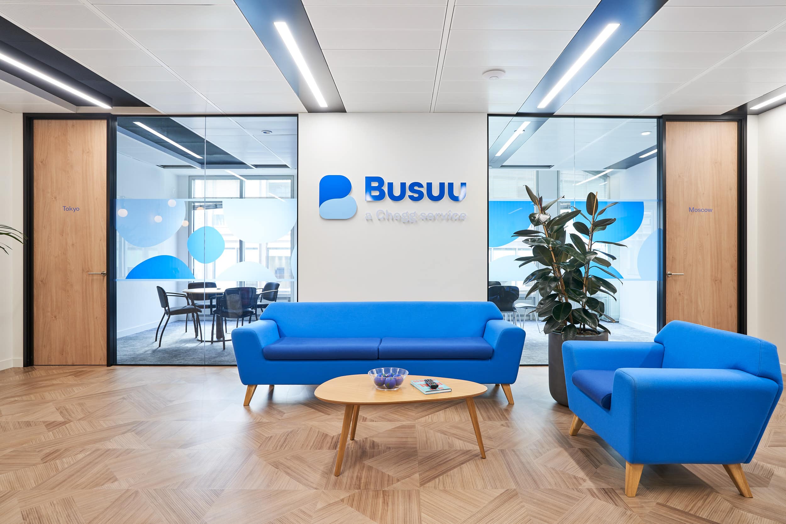 Busuu office design and build by AIS. Reception area with blue sofas reflective of the Busuu corporate branding.