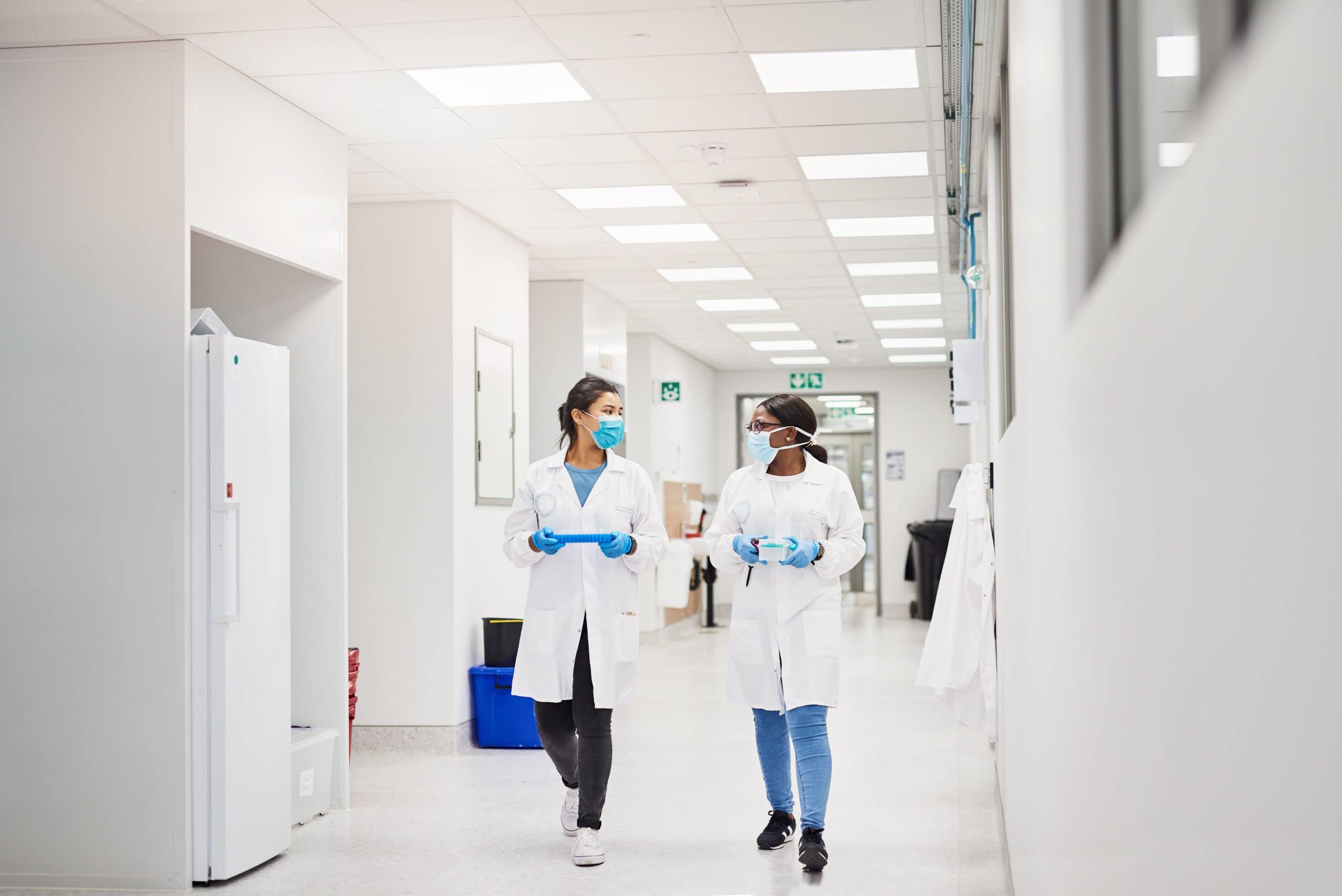 Two female scientists walking down the corridor of an AIS designed office-to-lab conversion.