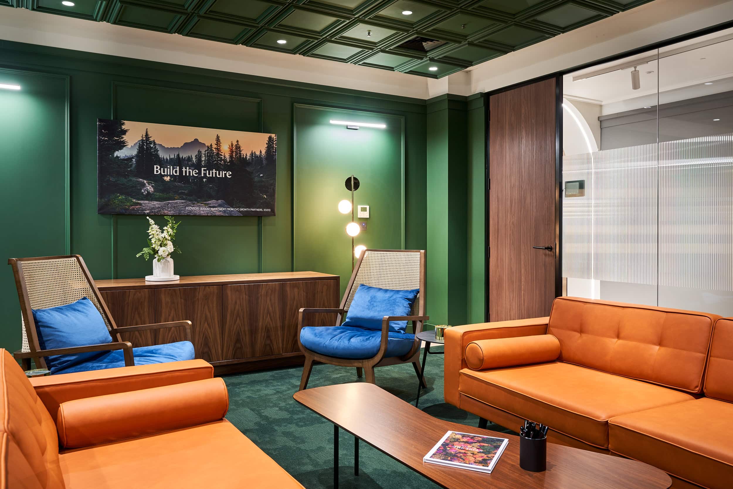 Office furniture by AIS, meeting room with two tan leather sofas and mid-century style coffee table.